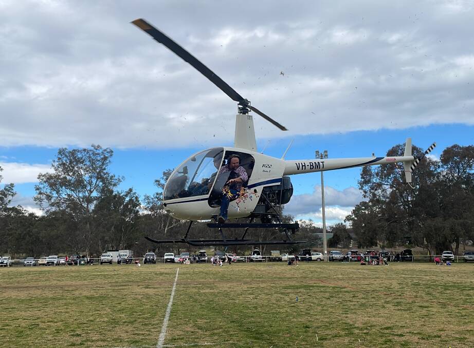 A helicopter performs a lolly drop at Jack Huxley Oval in Manildra. Picture by Dominic Unwin