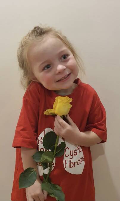 Izzy Weekes with one of the roses that her mum Sarah will be selling for 65 Roses Day, raising awareness and funds for cystic fibrosis. Picture supplied.