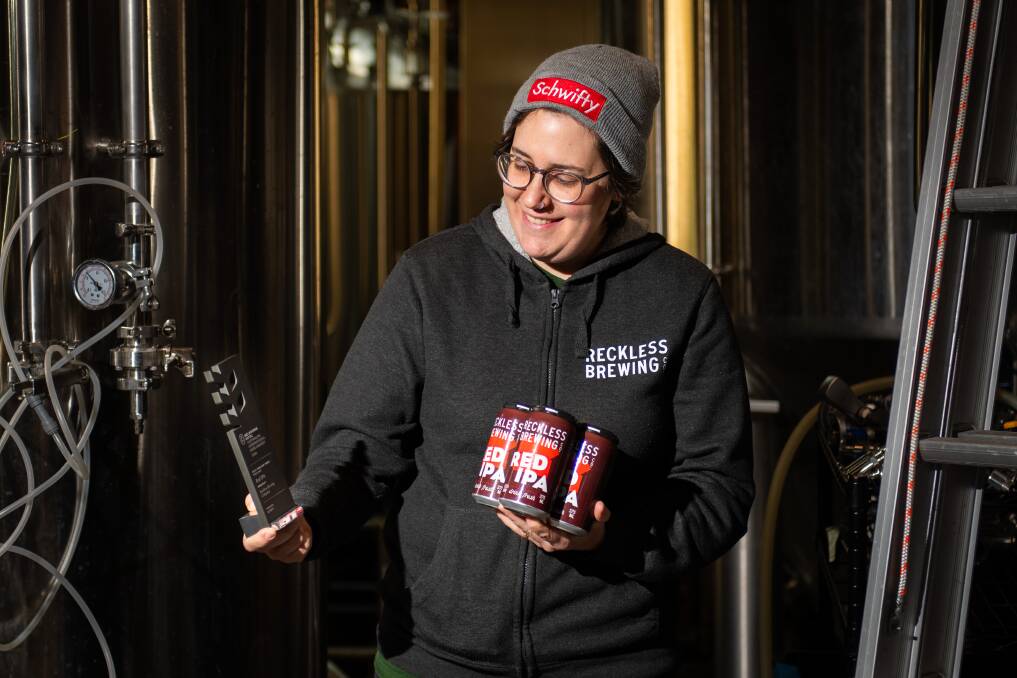 Co-founder of Reckless Brewing Co. Grace Fowler with the award winning Red IPA and the trophy out where all the brewing is done. Picture by James Arrow
