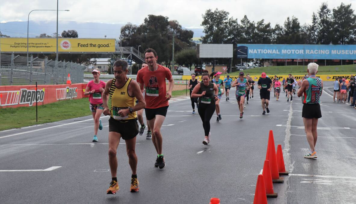Runners crossing the line after running a 'hot lap' around Mount Panorama. Picture by Amy Rees