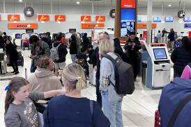 Jetstar passengers wait as check-in kiosks are closed due to a global IT outage at the Gold Coast Airport in Bilinga. Picture by AAP. 