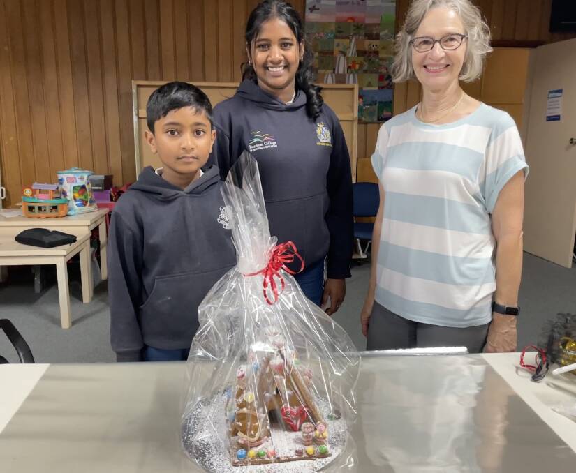 Dushant Jaganthan and his sister Thamilnila Jaganthan with their gingerbread house creation and event co-organiser Sue Gunter. Picture by Alise McIntosh
