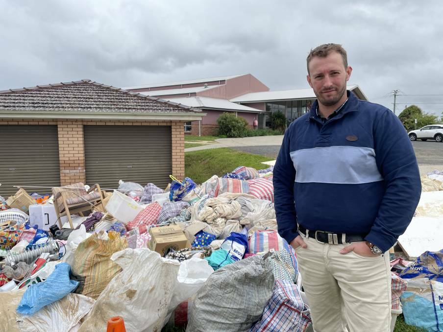 Elliot Redwin stood with a pile of damaged goods out the front of the HopeCare sorting facility in 2022. Picture by Alise McIntosh