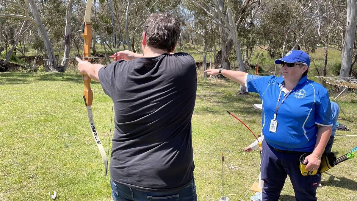 Bathurst Archers vice president Kellie May (right) instructs newcomer Tony Austin on how to shoot a bow and arrow. Picture by Bradley Jurd. 