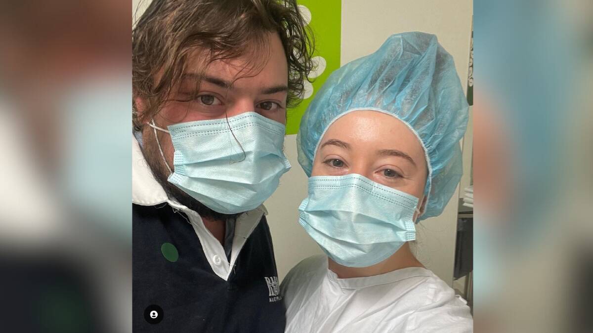 Thomas Elliston and Simone Lambley pictured in face masks and Simone wearing a hospital cap and gown during the IVF process. Picture is supplied