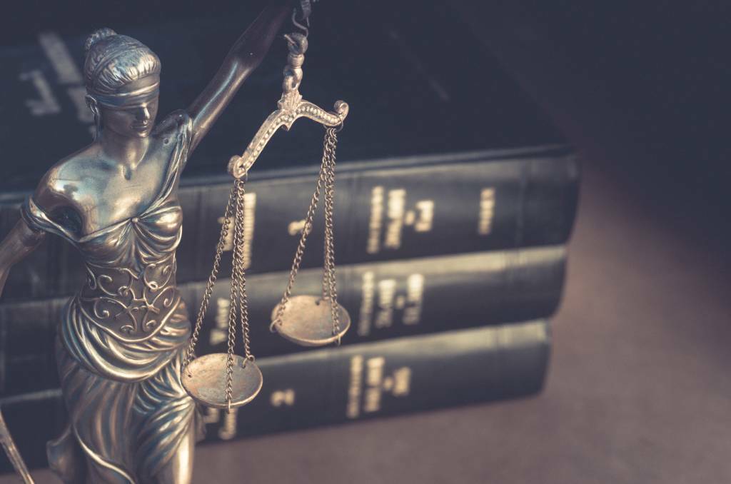 A bronze Lady Justice statue placed in front of a bundle of law books. File picture