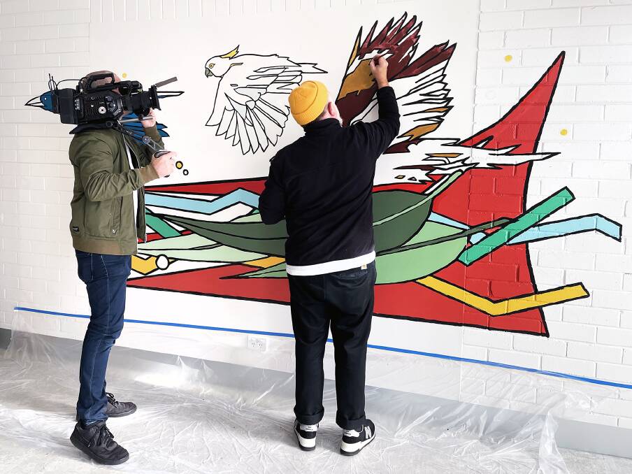 Mural artist Sonny Day painting the gym wall in the Yaganda Bulabul building at Bloomfield Hospital in Orange. Sonny and the other local and regional artists have been filmed by Andrew Barnes of Geagle Productions. Photo: Steven Cavanagh, Arts OutWest.