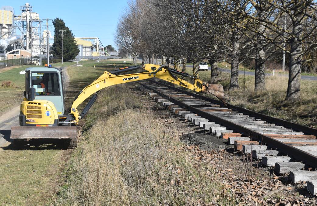Workers nudge rails into straight lines near Oberon in July. Picture by Peter Bowditch