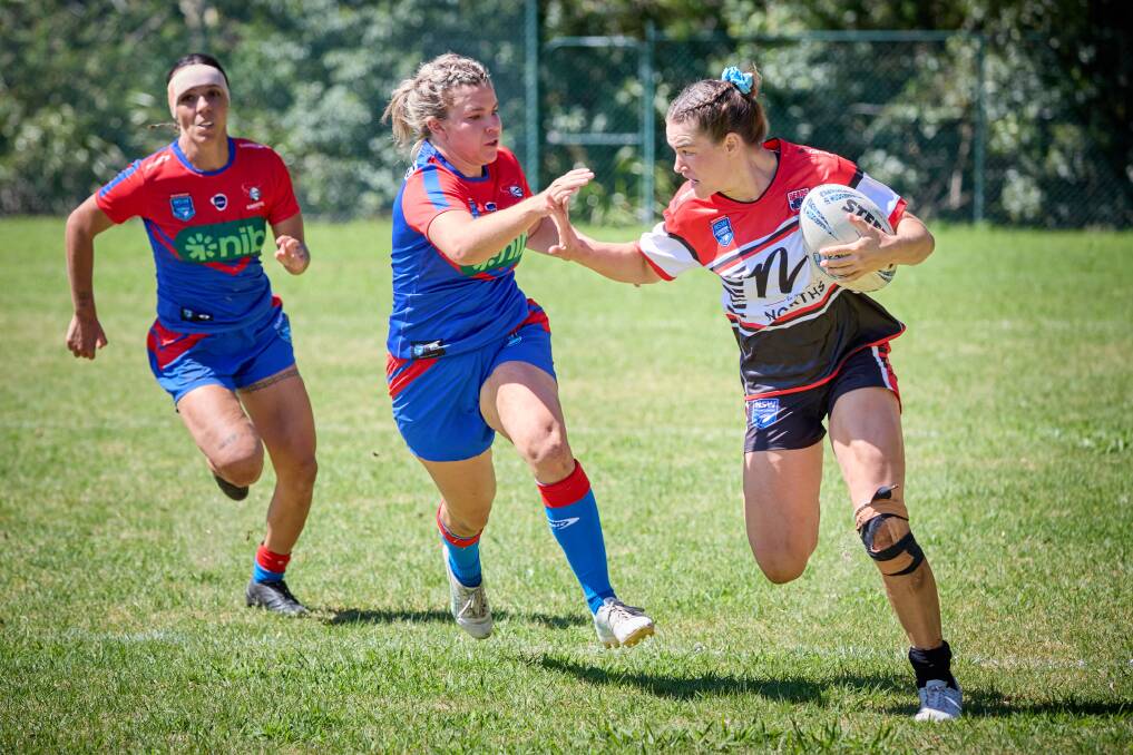 Jakiya Whitfeld moves to fend off a Newcastle rival in the opening round of the NSW Women's Premiership. Picture by Jim Walker Photography