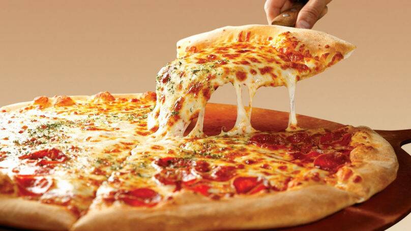 A person takes a slice of pizza. File picture