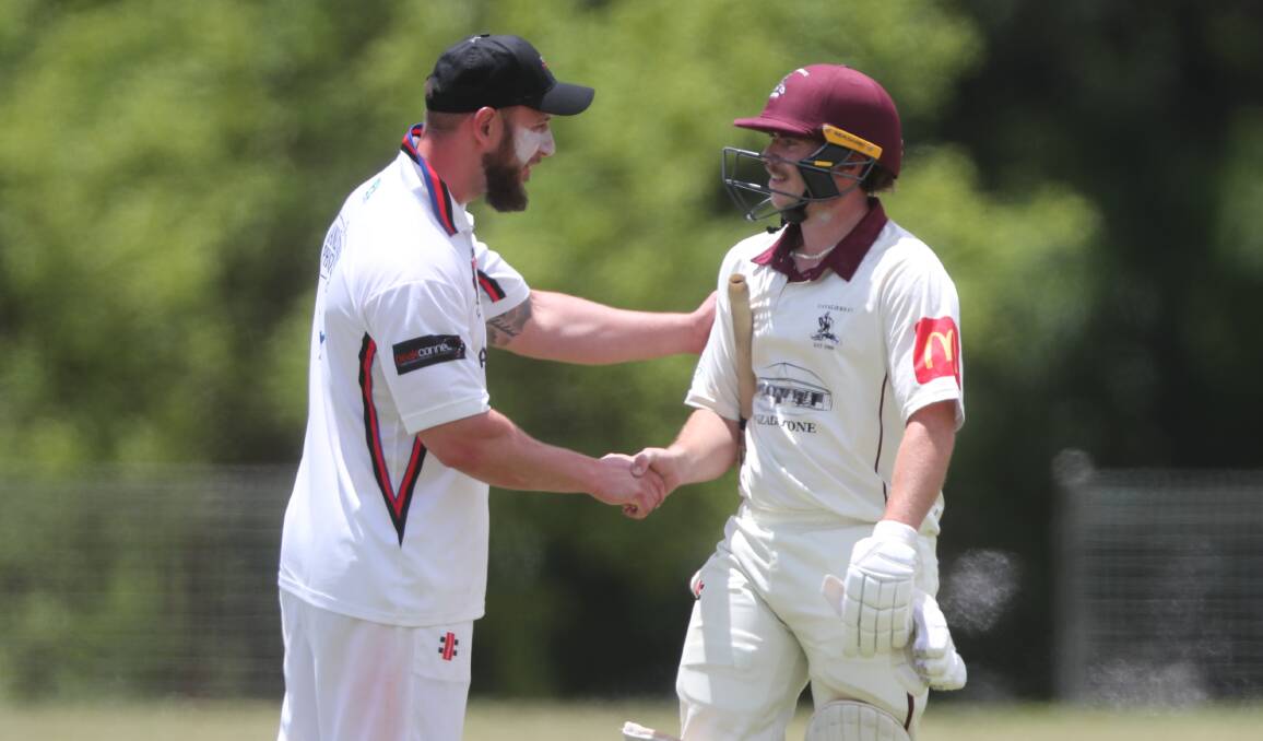 Mick Hutchinson congratulates Cameron Laird after the Cavs batter reached his century. Picture by Phil Blatch.