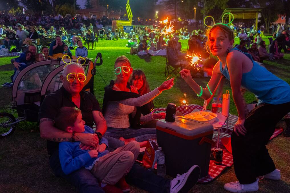 A family with sparklers and glow sticks enjoying Party in the Park on New Year's Eve. Picture by James Arrow