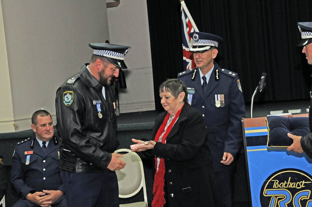 PAUL QUINN MEMORIAL AWARD: Sergeant Dave Parsons is presented with his award by the mother of slain police officer Paul Quinn, Barbara Quinn, and Superintendent Michael Robinson. Photo: PHILL MURRAY	052313ppolice1
